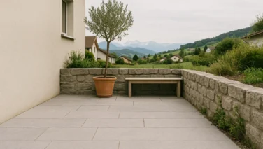 Mediterrane Gartenterrasse mit hellem Naturstein, Pflanzen und warmen Farbtönen