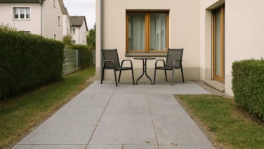 Moderner Reihenhausgarten mit Naturstein-Terrasse, schmalem Weg und klar gefasstem Sitzplatz