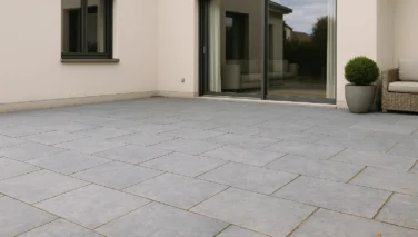 Moderne Terrasse mit Natursteinplatten in ruhigen Grautönen vor einem zeitgemässen Haus